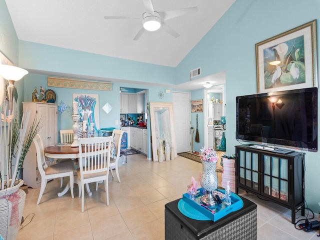 dining space with ceiling fan, light tile patterned floors, and high vaulted ceiling