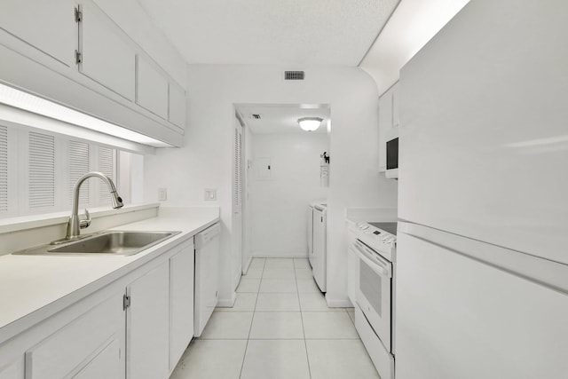 kitchen featuring light tile patterned flooring, sink, white appliances, and white cabinetry