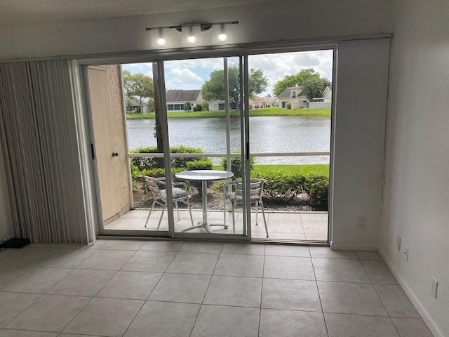 tiled empty room with a water view and a textured ceiling