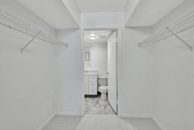 bathroom with a shower with door, vanity, and toilet