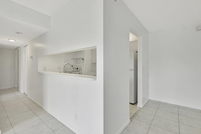 kitchen with white cabinetry, separate washer and dryer, white appliances, light tile patterned floors, and a textured ceiling