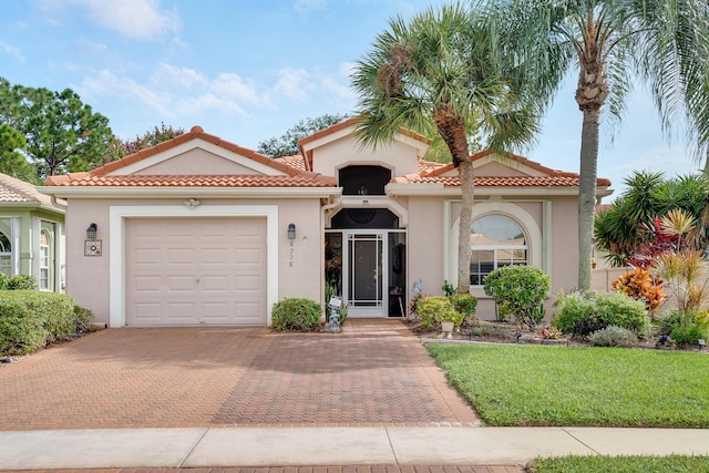 8228 Brindisi Ln, Boynton Beach, FL 33472 - mediterranean / spanish house featuring decorative driveway, stucco siding, an attached garage, and a tiled roof