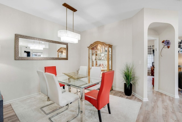 8228 Brindisi Ln, Boynton Beach, FL 33472 - dining area featuring arched walkways, wood finished floors, baseboards, and a chandelier