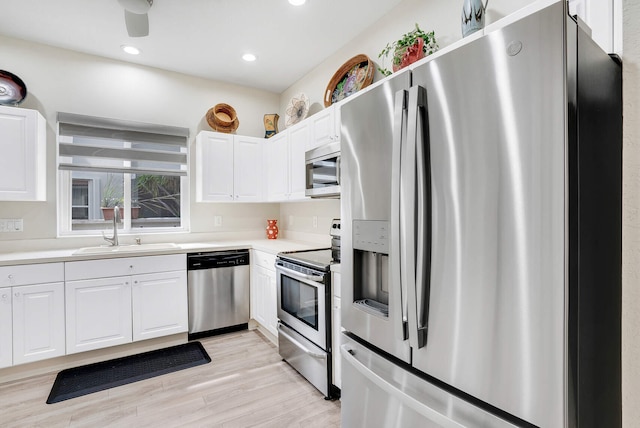 8228 Brindisi Ln, Boynton Beach, FL 33472 - kitchen featuring stainless steel appliances, a sink, white cabinets, light wood finished floors, and recessed lighting