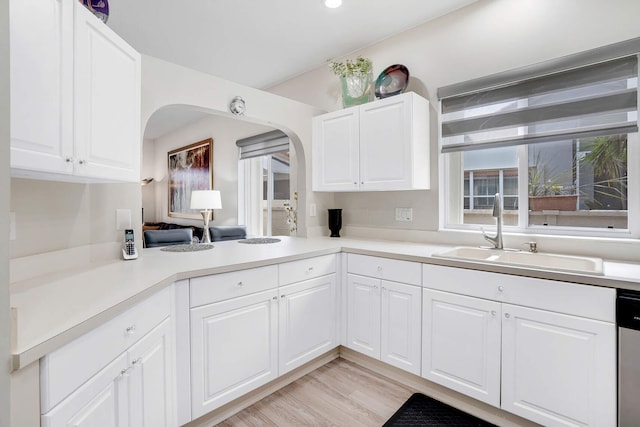 8228 Brindisi Ln, Boynton Beach, FL 33472 - kitchen with a sink, light countertops, arched walkways, white cabinets, and recessed lighting