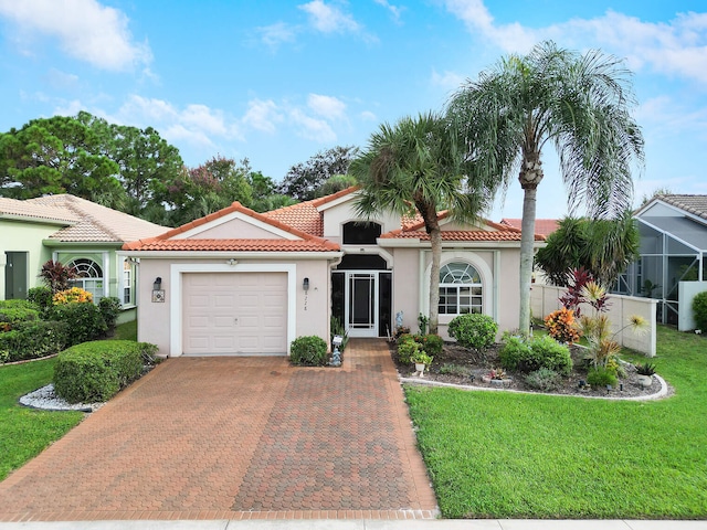 mediterranean / spanish home with a front lawn and a garage