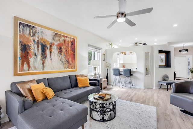 living room with light hardwood / wood-style flooring and ceiling fan