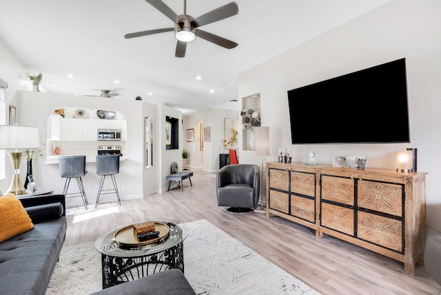 living room with light wood-type flooring and ceiling fan