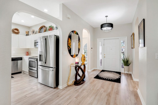8228 Brindisi Ln, Boynton Beach, FL 33472 - foyer featuring light wood-type flooring, baseboards, a chandelier, arched walkways, and recessed lighting