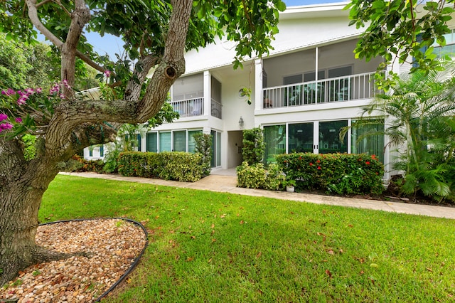 view of front of property with a balcony and a front lawn