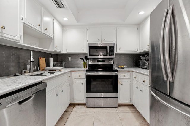 kitchen with appliances with stainless steel finishes, backsplash, and white cabinets