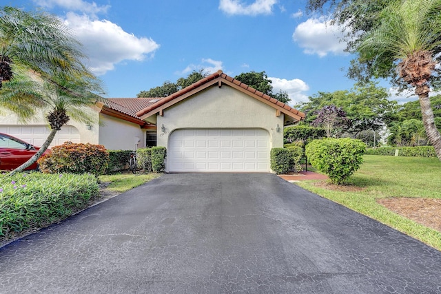 mediterranean / spanish-style home with a front yard and a garage