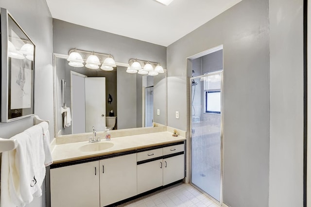 bathroom with vanity, toilet, tile patterned floors, and a shower with shower door