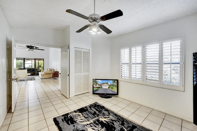 kitchen featuring lofted ceiling, a textured ceiling, ceiling fan, and light tile patterned floors