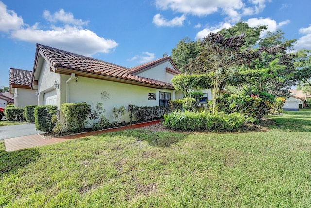 view of side of home featuring a yard and a garage