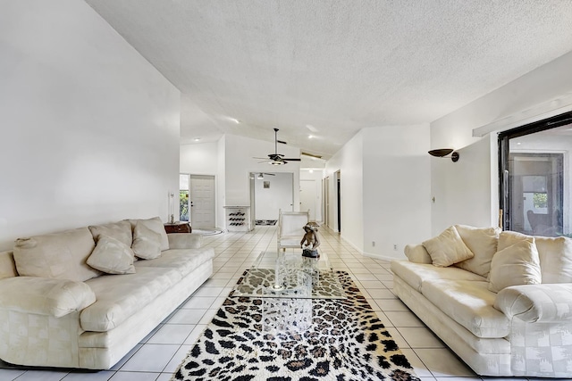 tiled living room with lofted ceiling, a textured ceiling, and ceiling fan