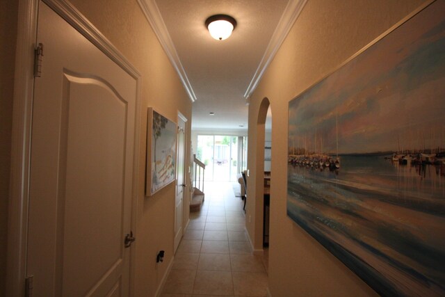 hallway featuring ornamental molding and light tile patterned floors