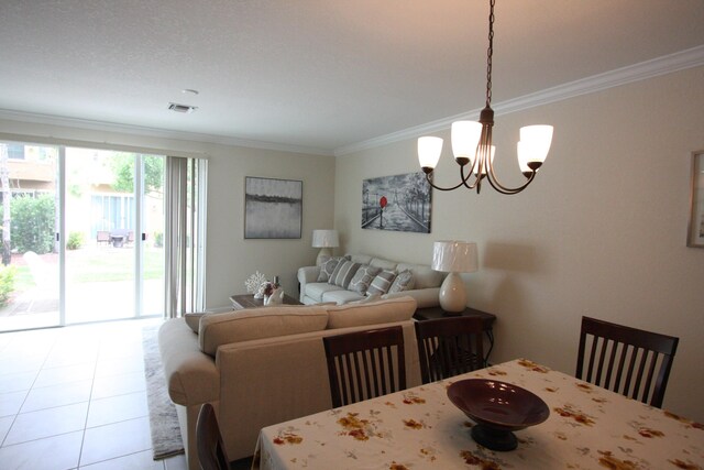 dining area with light tile patterned flooring, ornamental molding, and an inviting chandelier