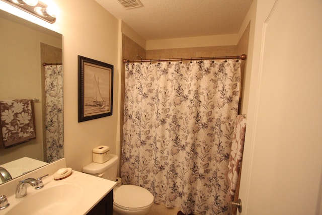 bathroom featuring a shower with shower curtain, a textured ceiling, vanity, and toilet