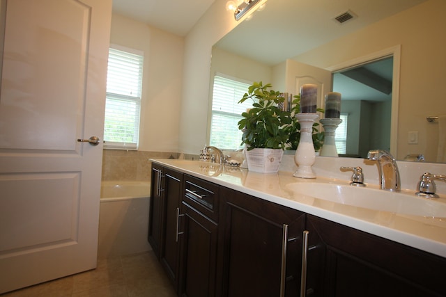 bathroom with vanity, a bathtub, and tile patterned flooring