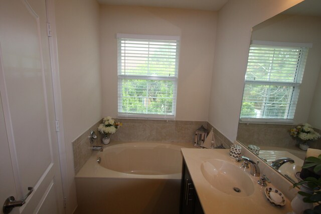 bathroom with a tub to relax in and vanity