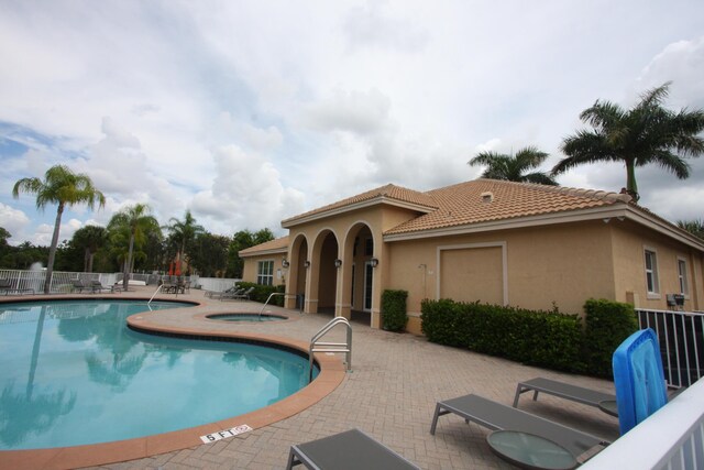 view of swimming pool featuring a patio area and a hot tub