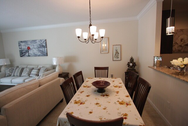 dining space featuring tile patterned flooring, ornamental molding, and a chandelier