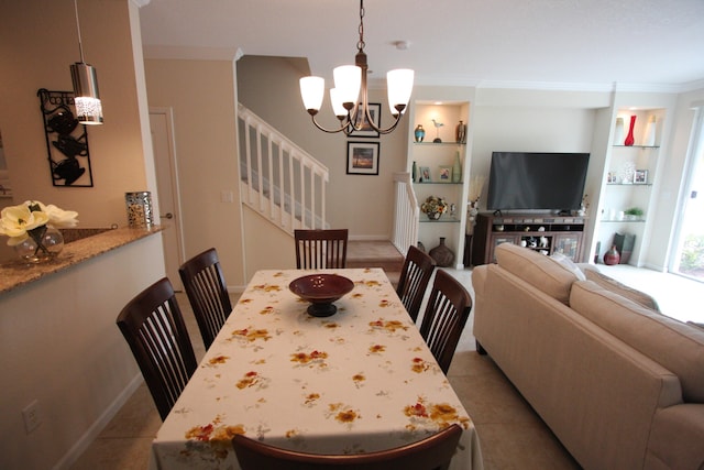 dining space featuring crown molding, light tile patterned floors, an inviting chandelier, and built in features