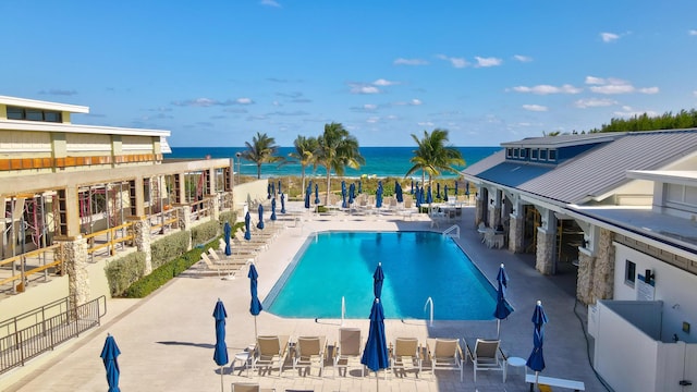 view of pool featuring a water view and a patio area