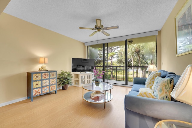 living room featuring floor to ceiling windows, wood finished floors, ceiling fan, a textured ceiling, and baseboards