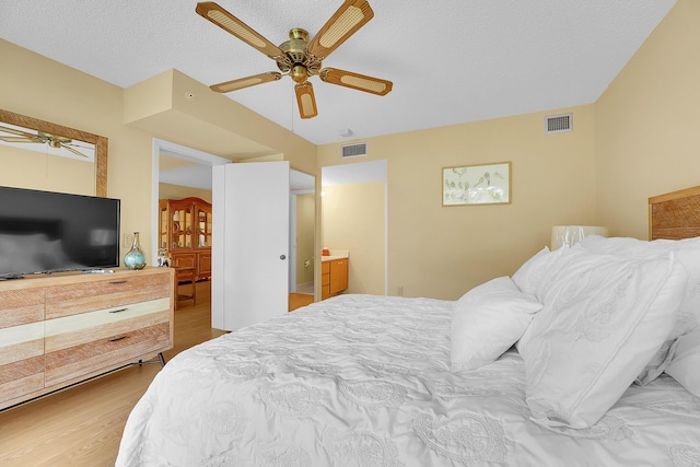 bedroom with wood finished floors, a textured ceiling, and ceiling fan