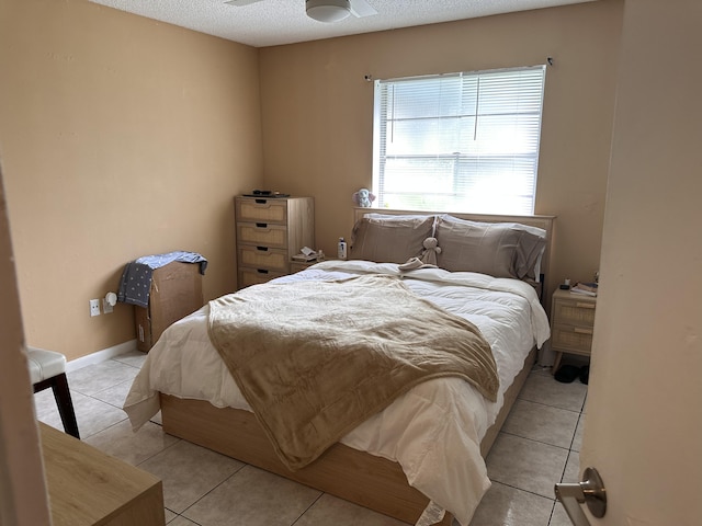 tiled bedroom with a textured ceiling and ceiling fan