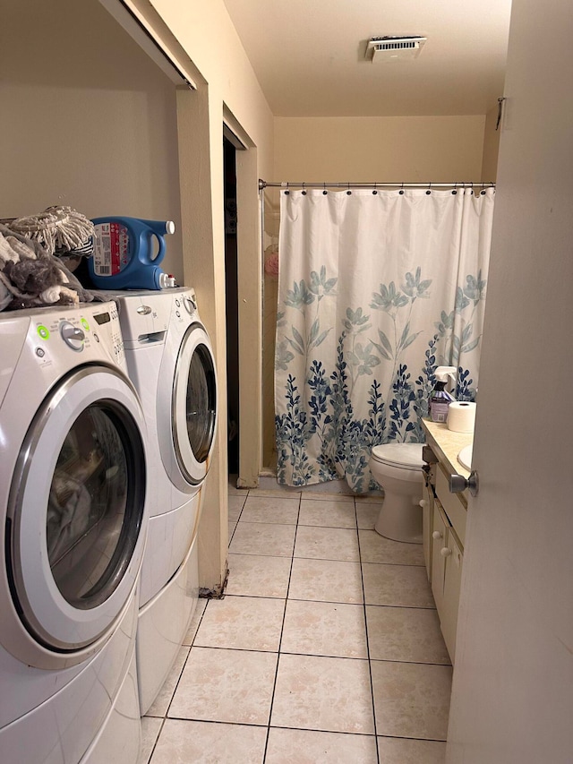 laundry area with light tile patterned flooring and washing machine and clothes dryer