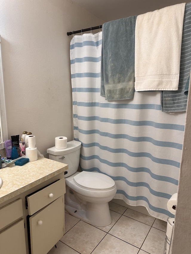 bathroom featuring walk in shower, vanity, toilet, and tile patterned flooring