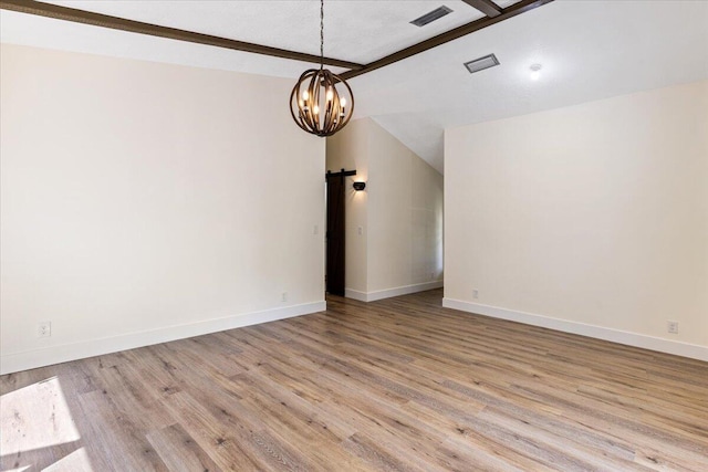 spare room with lofted ceiling with beams, light wood-type flooring, and a chandelier