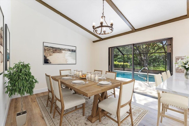 dining space featuring vaulted ceiling with beams, light wood-type flooring, and an inviting chandelier