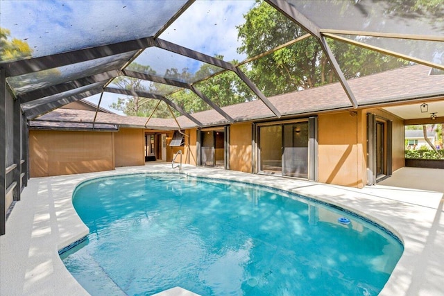 view of swimming pool with a patio area and a lanai