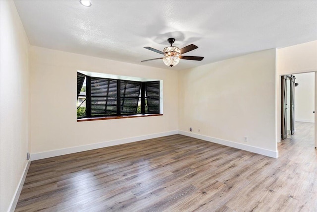 unfurnished room featuring light hardwood / wood-style floors and ceiling fan