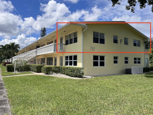 view of side of property with a yard and cooling unit