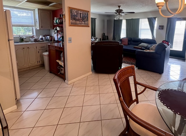 tiled dining room featuring sink, a textured ceiling, plenty of natural light, and ceiling fan