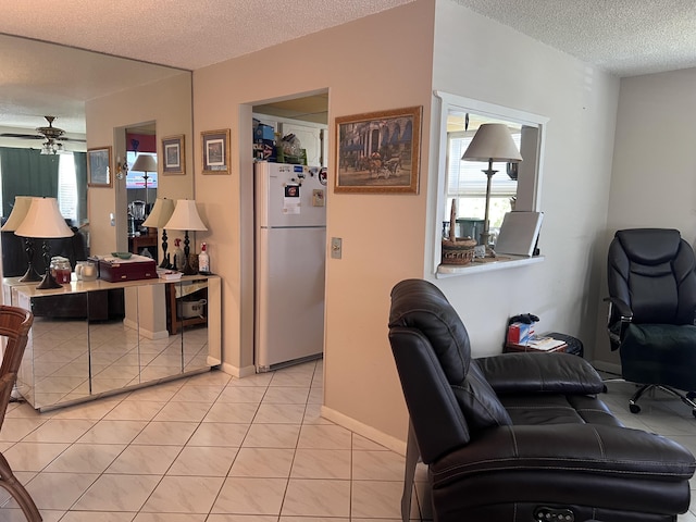 kitchen featuring light tile patterned floors, a textured ceiling, white fridge, and ceiling fan