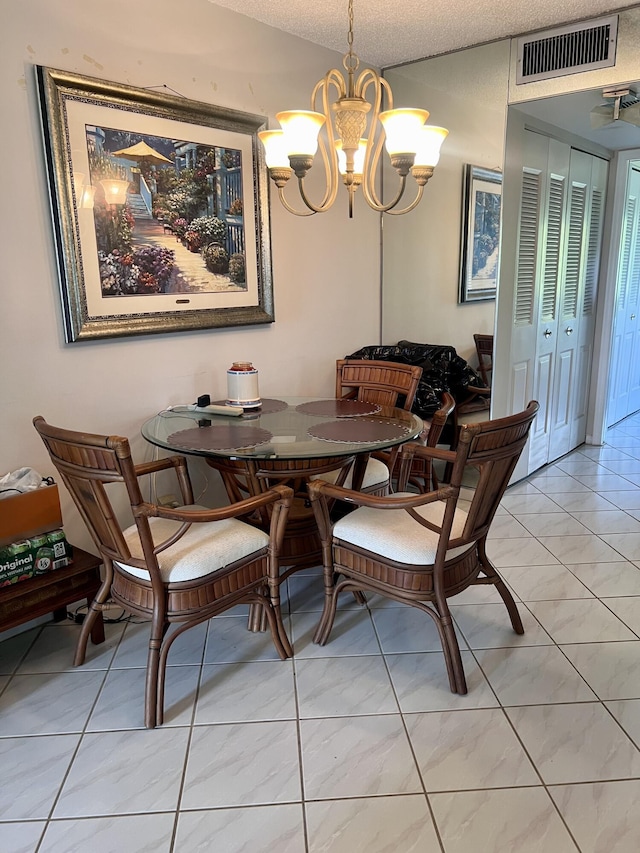 tiled dining space featuring a textured ceiling and a notable chandelier