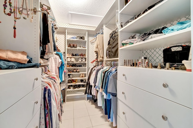 walk in closet with light tile patterned floors