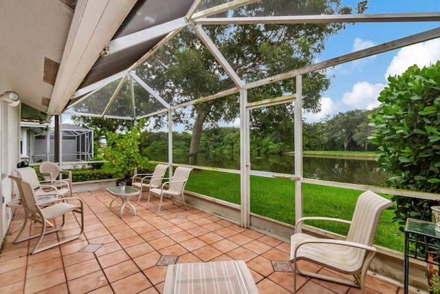 sunroom with lofted ceiling and a water view