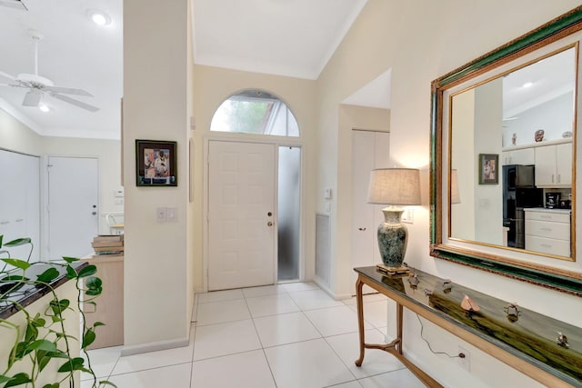 foyer entrance with crown molding, light tile patterned flooring, and ceiling fan