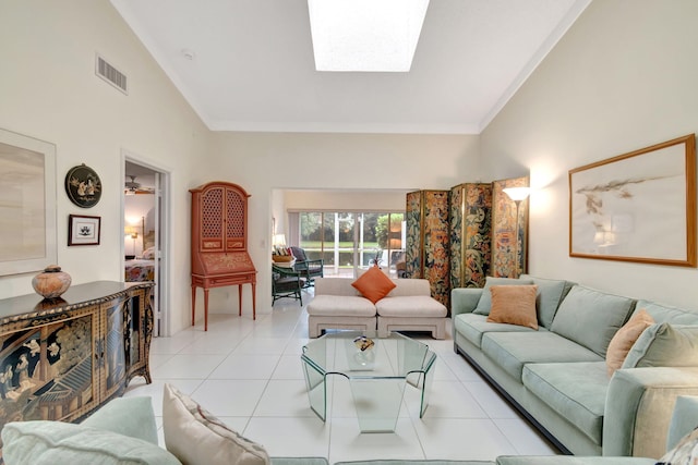 tiled living room featuring high vaulted ceiling and a skylight