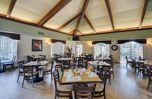 tiled dining room featuring high vaulted ceiling