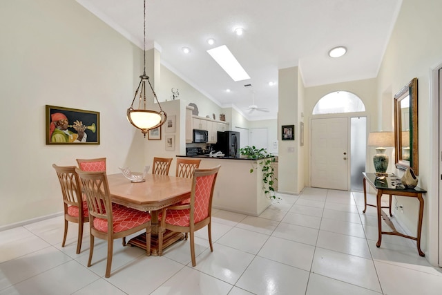 dining area featuring a skylight, crown molding, high vaulted ceiling, and light tile patterned flooring