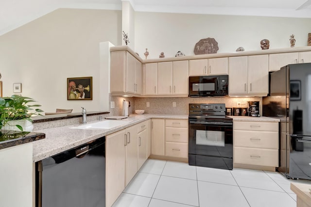 kitchen featuring decorative backsplash, light tile patterned floors, black appliances, lofted ceiling, and sink