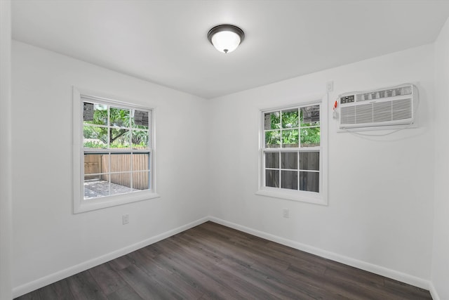 empty room featuring dark hardwood / wood-style flooring and a wall mounted AC